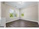 Bright bedroom featuring neutral walls, two windows with blinds, and sleek wood flooring at 634 Gardner Rd, Stockbridge, GA 30281