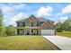 Inviting two-story brick home with a welcoming front porch, attached garage, and well-manicured lawn at 634 Gardner Rd, Stockbridge, GA 30281