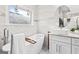 Bright bathroom featuring a modern soaking tub, marble walls, and a vessel sink with an oval mirror at 1450 Elizabeth Ln, East Point, GA 30344