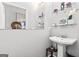 Charming powder room features a pedestal sink, decorative mirror, and elegant decor at 1450 Elizabeth Ln, East Point, GA 30344