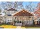 Charming two-story home featuring a quaint front porch, unique cedar shake details, and a landscaped front yard at 1450 Elizabeth Ln, East Point, GA 30344