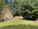 Spacious backyard with lush green grass, storage shed, mature trees, and an air conditioning unit at 416 Winterwood Dr, Stockbridge, GA 30281