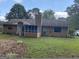Back exterior view featuring an enclosed porch and ample green space to relax at 416 Winterwood Dr, Stockbridge, GA 30281