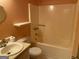 Small, peach-colored bathroom with a white sink, toilet, and bathtub at 416 Winterwood Dr, Stockbridge, GA 30281