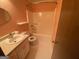 Peach-colored bathroom features white fixtures including a sink, toilet, and bathtub at 416 Winterwood Dr, Stockbridge, GA 30281