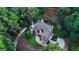 Aerial view of luxurious home features a circular driveway, pristine landscaping, and privacy from surrounding woods at 2878 Heather Row Sw Rdg, Lilburn, GA 30047
