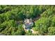 Aerial view of a house surrounded by lush greenery and mature trees, with a long driveway at 2878 Heather Row Sw Rdg, Lilburn, GA 30047