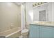 Full bath features a tub with shower and neutral tile, a light blue vanity and light walls at 2878 Heather Row Sw Rdg, Lilburn, GA 30047