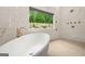 Marble bathroom showcases soaking tub, shower with nature view, and modern fixtures at 2878 Heather Row Sw Rdg, Lilburn, GA 30047