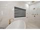 Elegant soaking tub near modern shower, marble walls, and window for serene bathroom experience at 2878 Heather Row Sw Rdg, Lilburn, GA 30047