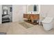 Stylish bathroom with modern double vanity, toilet, marble walls, and view to bedroom at 2878 Heather Row Sw Rdg, Lilburn, GA 30047