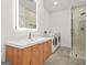 Modern bathroom featuring a sleek vanity, illuminated mirror, glass shower, and laundry at 2878 Heather Row Sw Rdg, Lilburn, GA 30047