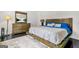 Bright bedroom showcasing a dresser with mirror and television, with dark wood floors and light rug at 2878 Heather Row Sw Rdg, Lilburn, GA 30047