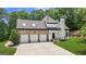 Garage elevation showcasing a three car garage with stone facade, as well as adjacent access stairway at 2878 Heather Row Sw Rdg, Lilburn, GA 30047