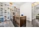 Well-lit office area with hardwood floors and a large shoe collection on custom shelving at 2878 Heather Row Sw Rdg, Lilburn, GA 30047