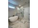 Luxurious bathroom featuring marble floors, free standing tub, glass enclosed shower, and natural light at 129 Silvercrest Dr # 57, Acworth, GA 30101