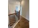 Second story hallway with hardwood floors and black iron railing overlooking the staircase at 129 Silvercrest Dr # 57, Acworth, GA 30101