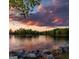 Scenic lake view with calm waters, lush trees, and a beautiful sunset sky, offering a serene escape at 129 Silvercrest Dr # 57, Acworth, GA 30101