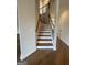 Staircase with wooden steps, white risers, and iron railing at 129 Silvercrest Dr # 57, Acworth, GA 30101