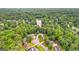 Sprawling neighborhood aerial view showing multiple homes nestled amongst mature trees with a lake backdrop at 134 Mellington Ln, Peachtree City, GA 30269