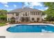 Back of house featuring a swimming pool, balcony and stone waterfall feature at 134 Mellington Ln, Peachtree City, GA 30269