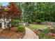 Landscaped backyard featuring a stone pathway leading to a pool and lush garden areas at 134 Mellington Ln, Peachtree City, GA 30269
