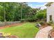 Lush backyard with a stone pathway, mature trees, and beautifully landscaped garden beds at 134 Mellington Ln, Peachtree City, GA 30269
