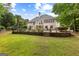 Expansive backyard featuring a swimming pool, stone retaining wall and lush landscaping at 134 Mellington Ln, Peachtree City, GA 30269