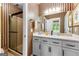 Elegant bathroom featuring striped wallpaper, white cabinets, granite counters, and a glass-enclosed shower at 134 Mellington Ln, Peachtree City, GA 30269
