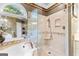 Lavish bathroom with glass shower, marble tiling, and arched windows for natural light at 134 Mellington Ln, Peachtree City, GA 30269