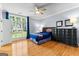 Bright bedroom with wood floors, ceiling fan, and a large window overlooking a landscaped yard at 134 Mellington Ln, Peachtree City, GA 30269