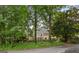 Exterior view of the home showcasing lush surrounding trees, a fenced yard, and architectural details at 134 Mellington Ln, Peachtree City, GA 30269