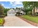 Charming home with manicured front yard, brick path, and long driveway to 3-car garage at 134 Mellington Ln, Peachtree City, GA 30269