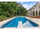 Beautiful in-ground pool featuring a diving board, surrounded by lush landscaping and mature trees at 134 Mellington Ln, Peachtree City, GA 30269