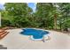 Beautiful in-ground pool surrounded by lush greenery and landscaped patio at 134 Mellington Ln, Peachtree City, GA 30269