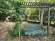 Backyard with an outdoor swing covered with vines and greenery overhead at 1129 River Green Ct, Mcdonough, GA 30252