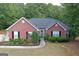 Charming brick home featuring a well-manicured lawn, lush landscaping, and a welcoming front entrance at 1129 River Green Ct, Mcdonough, GA 30252