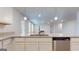 Close up of kitchen island with stainless dishwasher, faucet, granite counters and pendant lighting at 95 Jacoby Dr # 103, Fairburn, GA 30213
