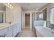 Bathroom featuring a large double sink vanity, glass enclosed shower, and soaking tub at 112 Felicity Pike, Locust Grove, GA 30248