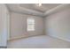 Bright bedroom features a tray ceiling, plush carpeting, and natural light from the window at 112 Felicity Pike, Locust Grove, GA 30248