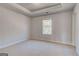 Bright bedroom features a tray ceiling, plush carpeting, and natural light from the window at 112 Felicity Pike, Locust Grove, GA 30248