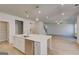 Open living space boasts a kitchen island, stainless appliances, and pendant lighting at 112 Felicity Pike, Locust Grove, GA 30248