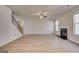 Open living area showcases modern fireplace, adjacent staircase, and plank flooring at 112 Felicity Pike, Locust Grove, GA 30248