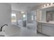 Bright bathroom showcases dual vanities, a soaking tub, and backyard views from a window at 120 Felicity Pike, Locust Grove, GA 30248