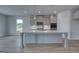 Kitchen featuring a large island, pendant lights, neutral cabinetry, and stainless steel appliances at 120 Felicity Pike, Locust Grove, GA 30248