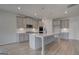 Well-lit kitchen boasts modern grey cabinets, stainless appliances, and a large island with pendant lighting at 120 Felicity Pike, Locust Grove, GA 30248