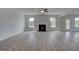 Living room showcasing a fireplace with mantle between two windows and wood-look flooring at 120 Felicity Pike, Locust Grove, GA 30248