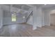 Open-concept living space with stairs, dining area with chandelier and bathroom entrance, and lots of light at 120 Felicity Pike, Locust Grove, GA 30248