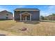 Backyard view of new construction features a covered porch and lawn at 221 Ruthe Cv, Locust Grove, GA 30248