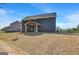 Backyard shot with a large lawn and covered porch of new construction at 221 Ruthe Cv, Locust Grove, GA 30248